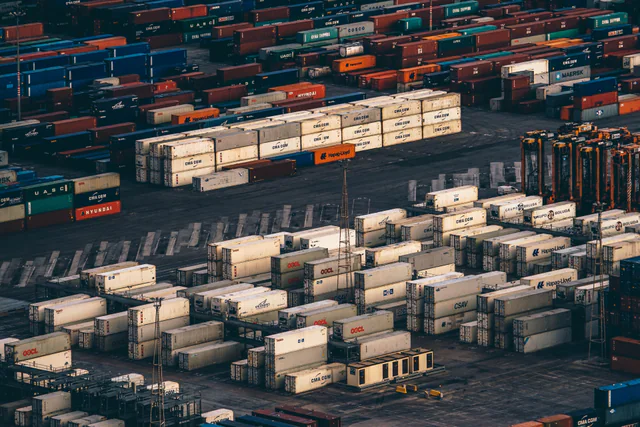 An aerial view of thousands of stacked shipping containers from Maersk, CMA CGM, Hapag-Lloyd, China Shipping and other lines filling a container terminal.