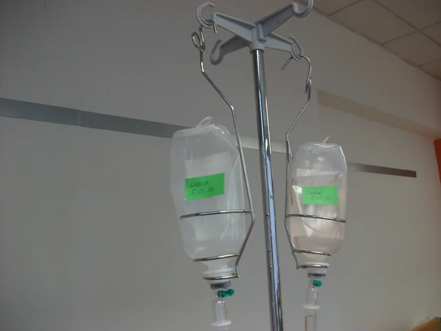 An intravenous infusion line and drip chamber hanging on a clinical stand, with no people in frame.