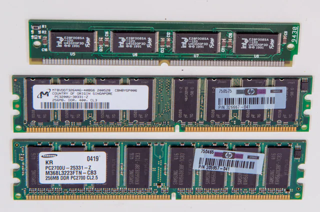 Close-up of computer RAM memory modules with rows of black memory chips mounted on a green circuit board.