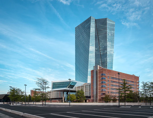 The European Central Bank headquarters in Frankfurt beneath a blue sky.