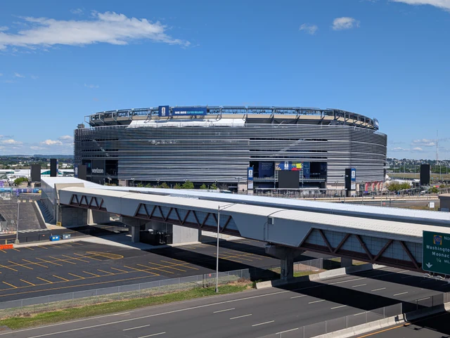 Exterior of MetLife Stadium wrapped for the 2026 FIFA World Cup beneath a blue sky.
