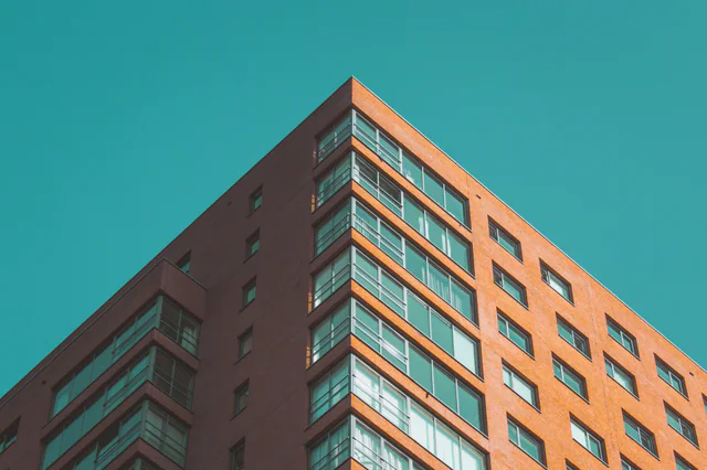 Low-angle view of the red facade and windows of an apartment building at Zuidplein in Rotterdam.